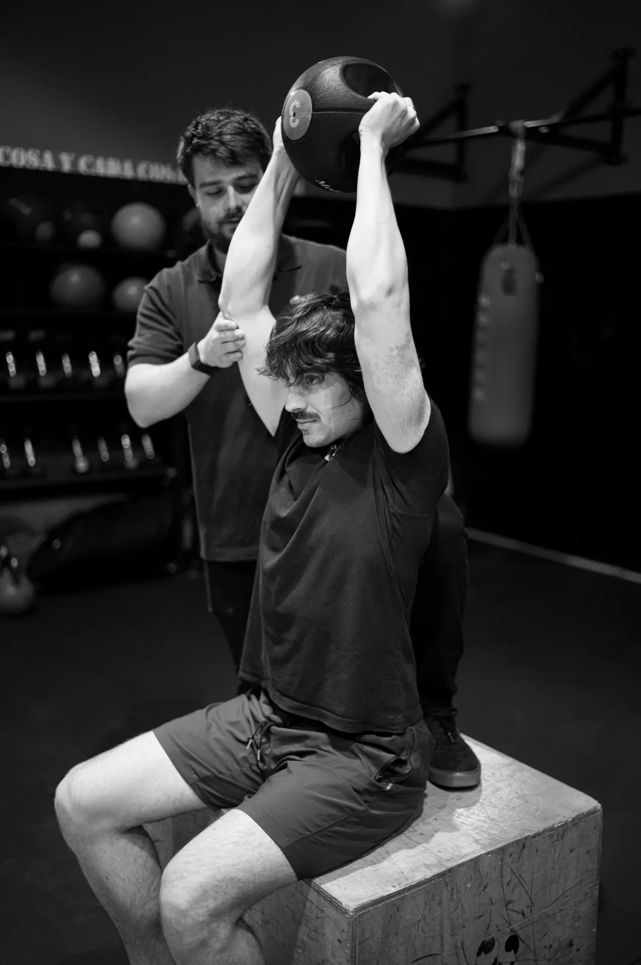 Ejercicio de press por encima de la cabeza en el gimnasio, blanco y negro, en la clínica de Iñigo Goikoetxea, fisioterapeuta en Bilbao