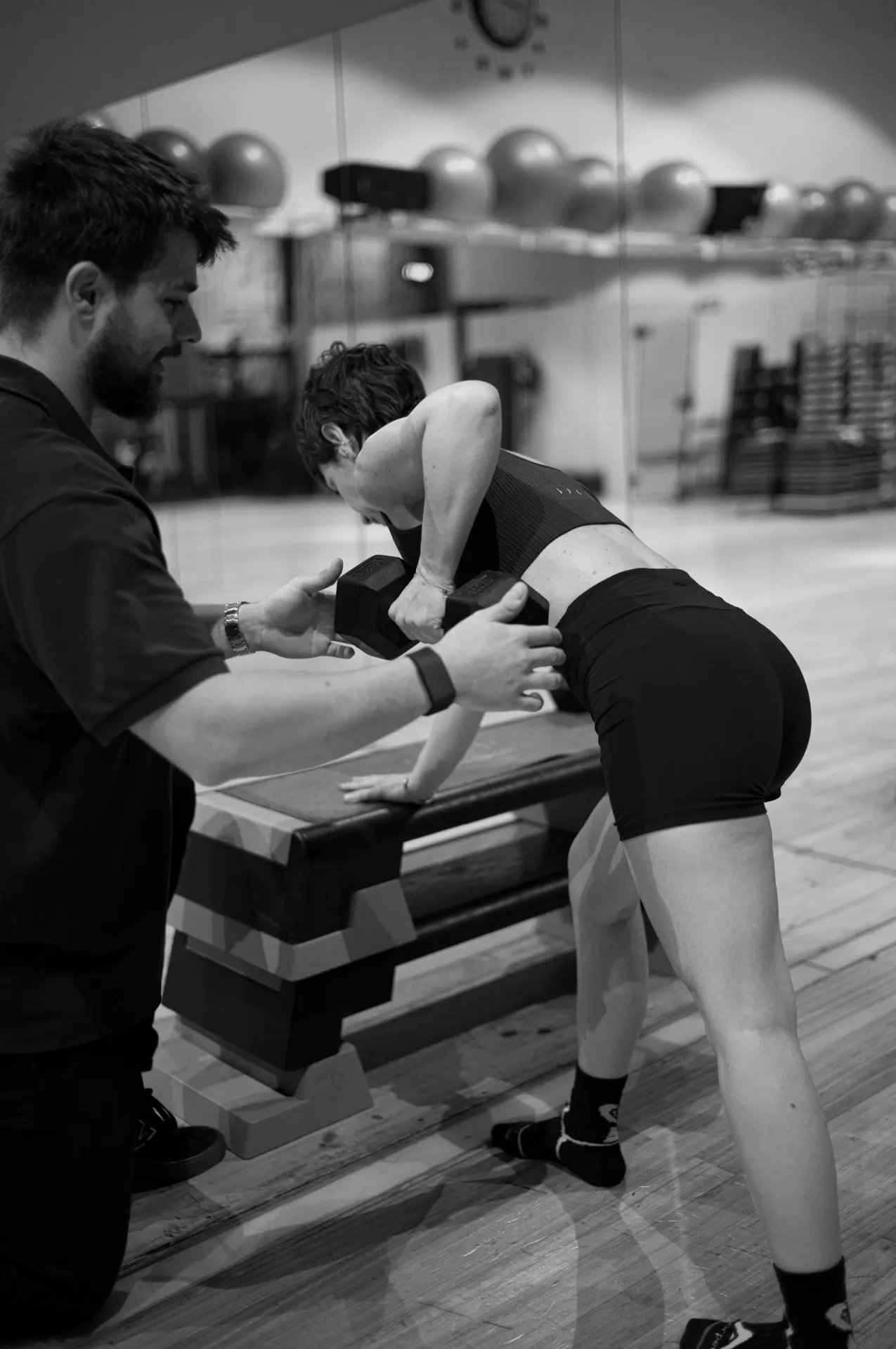 Ejercicio con step o cajón durante el entrenamiento guiado, blanco y negro, en la clínica de Iñigo Goikoetxea, fisioterapeuta en Bilbao