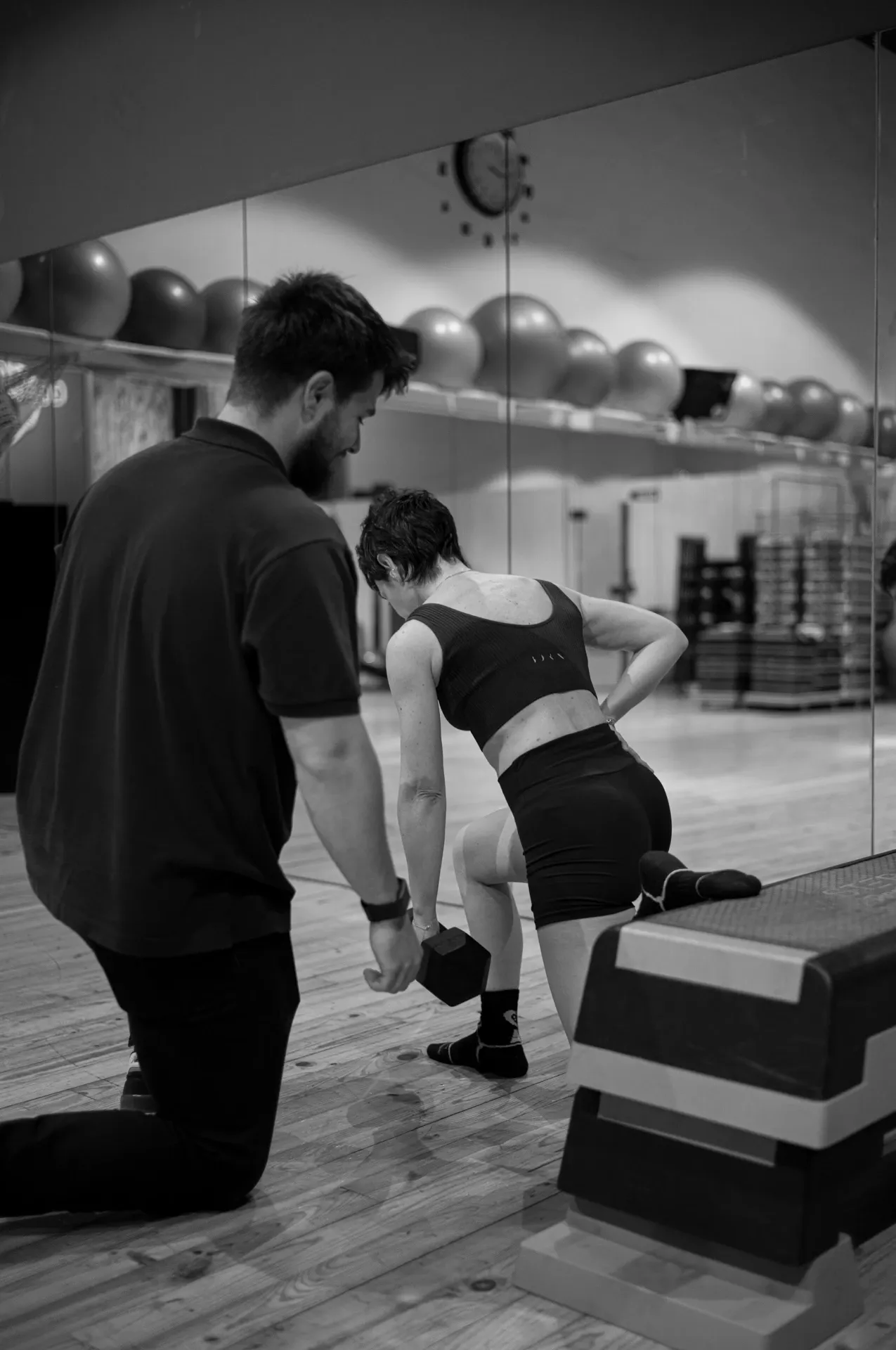 Plano amplio del gimnasio con sesión de coaching, blanco y negro, en la clínica de Iñigo Goikoetxea, fisioterapeuta en Bilbao